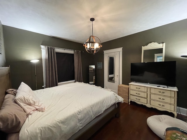 bedroom with dark hardwood / wood-style flooring and a chandelier