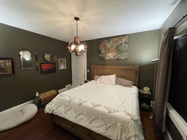 bedroom featuring dark hardwood / wood-style floors and a chandelier