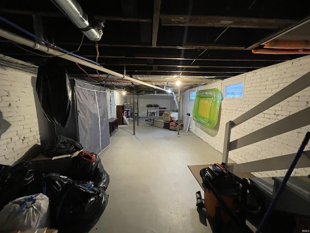 basement featuring brick wall