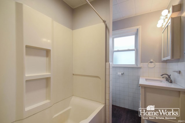 bathroom featuring vanity and tile walls