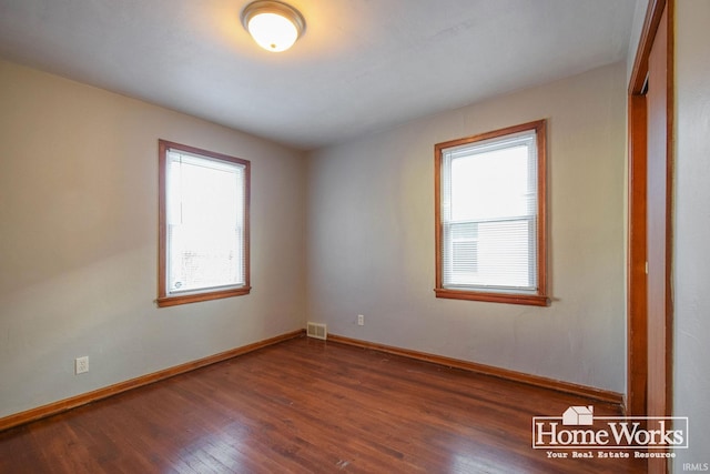 unfurnished room featuring dark hardwood / wood-style floors and a wealth of natural light