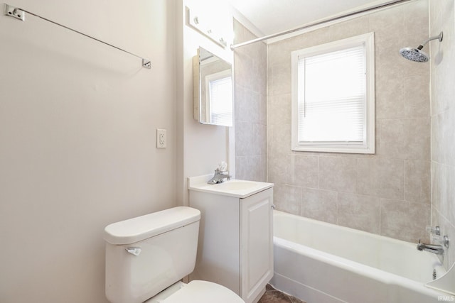 full bathroom with vanity, tiled shower / bath, toilet, and a healthy amount of sunlight