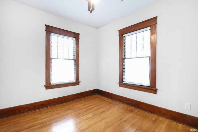 empty room with hardwood / wood-style flooring and plenty of natural light