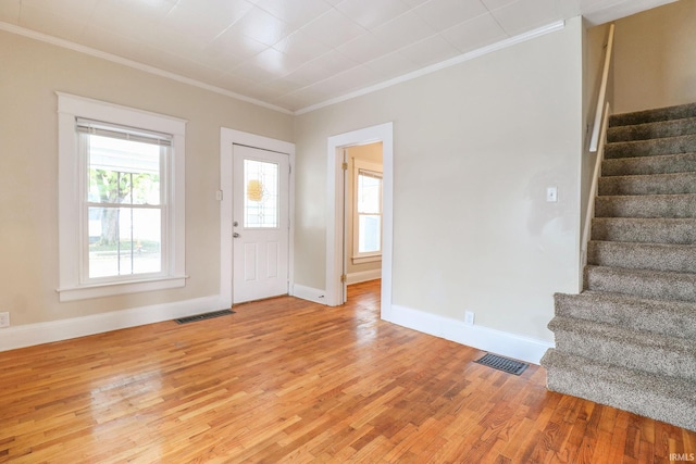 foyer entrance with crown molding and light wood-type flooring