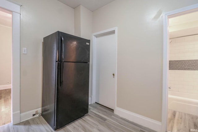 kitchen featuring black fridge and light hardwood / wood-style flooring