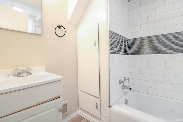 bathroom featuring tiled shower / bath combo and vanity