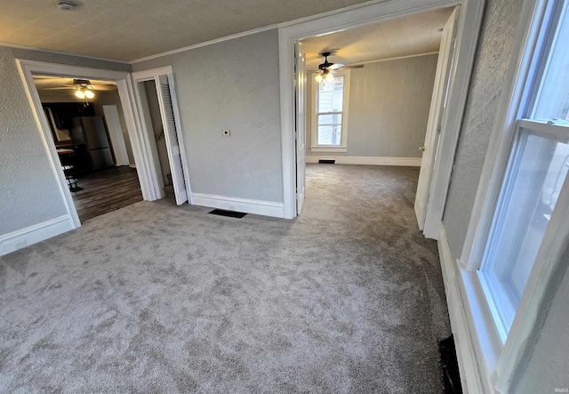 carpeted empty room featuring crown molding