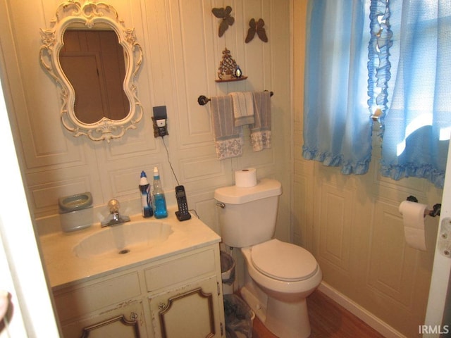 half bathroom with vanity and toilet