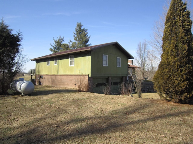 view of side of home featuring brick siding and a lawn