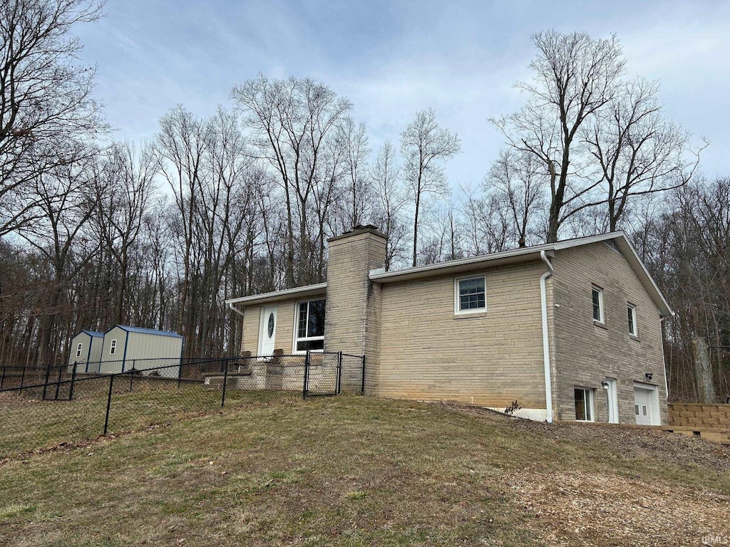 back of house featuring a garage and a yard