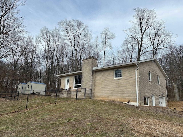 back of house featuring a garage and a yard