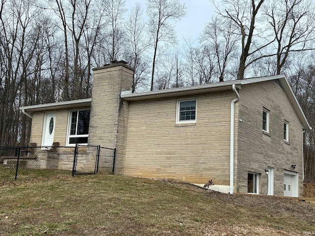 view of side of home featuring a garage and a yard