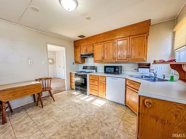 kitchen with dishwasher, sink, light tile patterned floors, and gas range