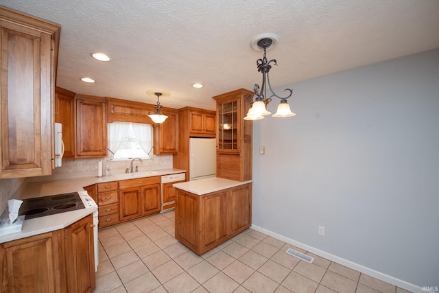 kitchen featuring white refrigerator, tasteful backsplash, sink, and pendant lighting