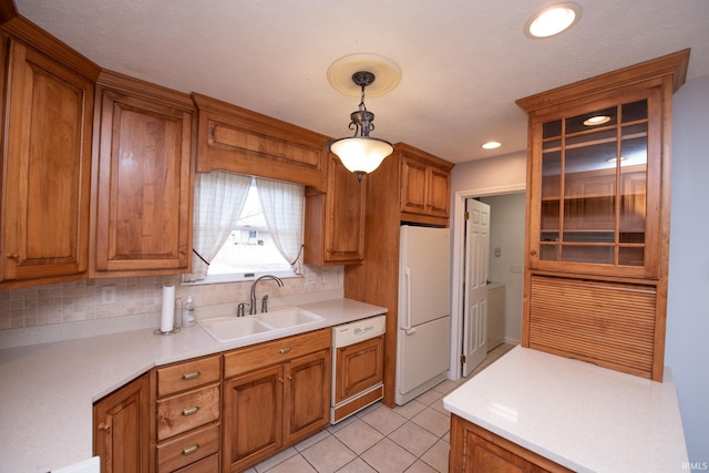 kitchen featuring sink, decorative light fixtures, white refrigerator, paneled dishwasher, and backsplash