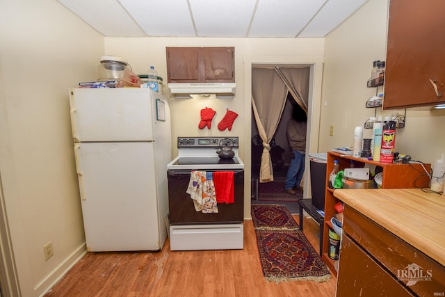 kitchen with a paneled ceiling, white appliances, and light hardwood / wood-style flooring