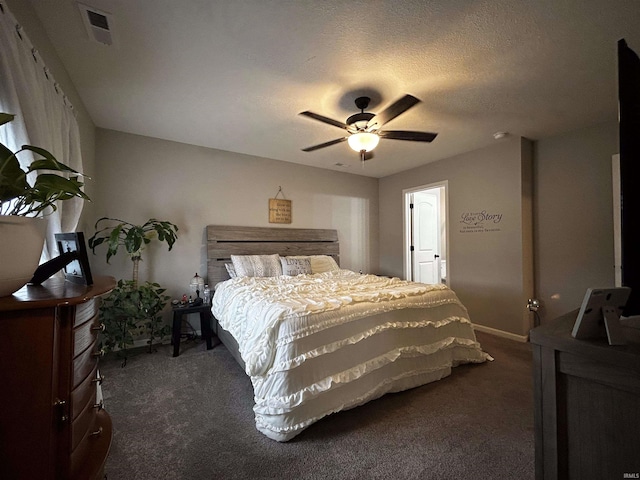 bedroom with dark colored carpet, a textured ceiling, and ceiling fan