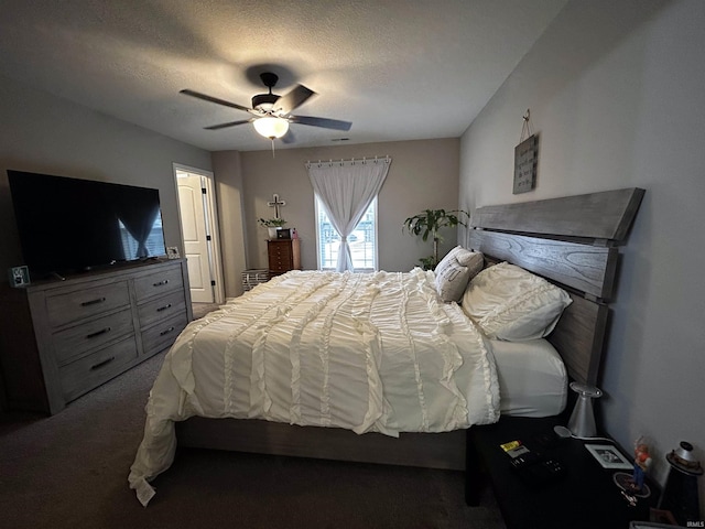 bedroom with ceiling fan, a textured ceiling, and dark carpet