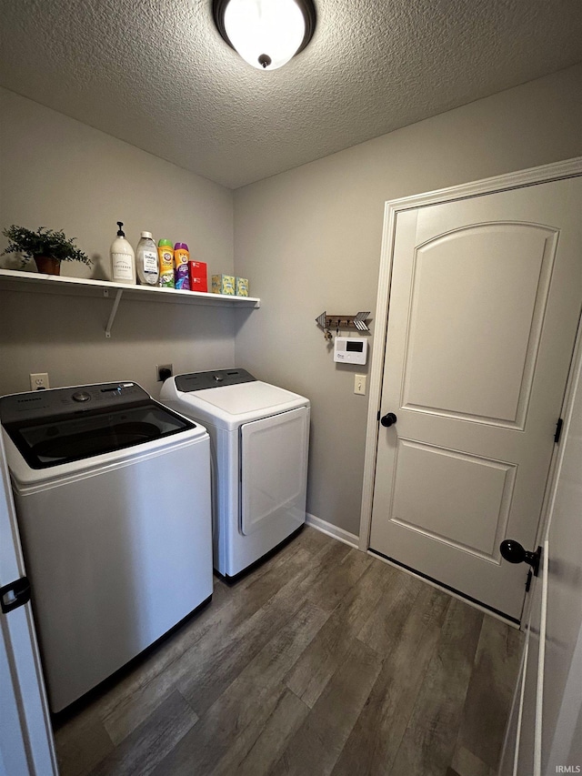 laundry room with a textured ceiling, washing machine and clothes dryer, and dark hardwood / wood-style flooring