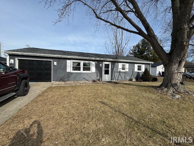 ranch-style home with a garage and a front lawn