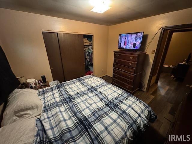 bedroom featuring dark hardwood / wood-style flooring and a closet