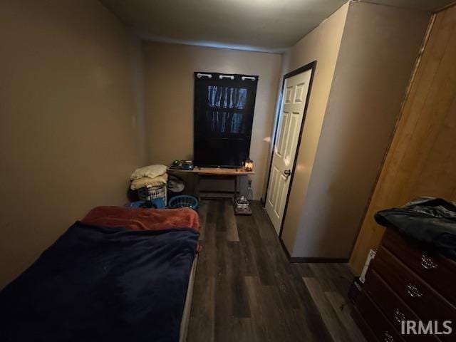 bedroom with dark hardwood / wood-style flooring