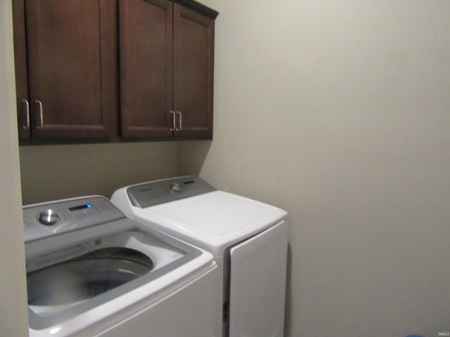 clothes washing area featuring cabinets and independent washer and dryer