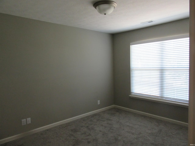 unfurnished room with dark carpet