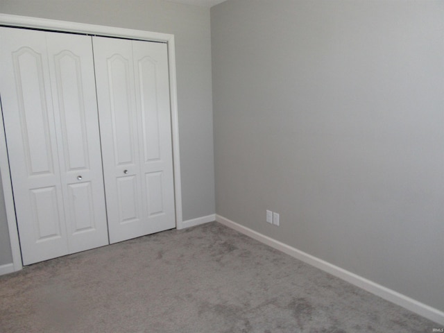 unfurnished bedroom with a closet and light carpet