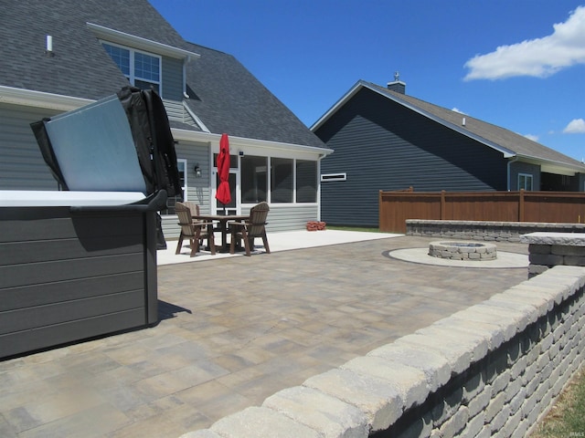 view of patio with a jacuzzi and an outdoor fire pit