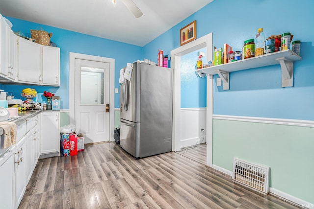 kitchen with white cabinetry, stainless steel fridge, ceiling fan, and light wood-type flooring