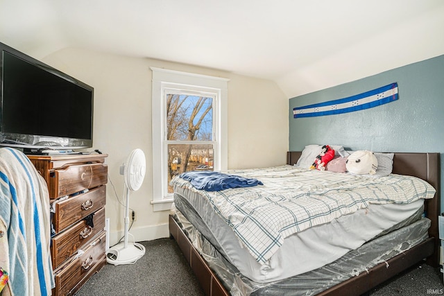 bedroom with lofted ceiling and dark carpet