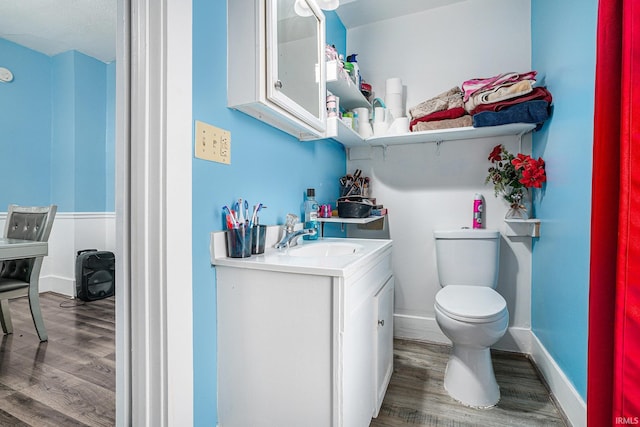 bathroom with vanity, hardwood / wood-style floors, and toilet