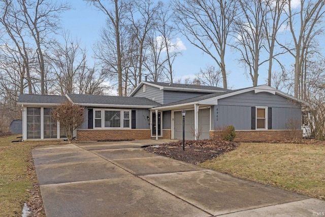 view of front facade with a garage, a sunroom, and a front yard