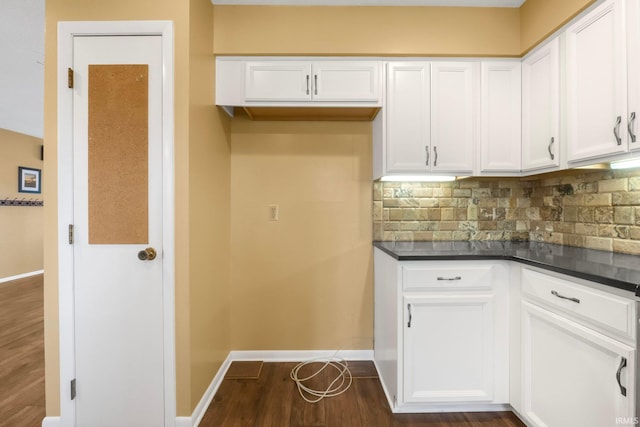 kitchen with dark wood-type flooring, decorative backsplash, and white cabinets