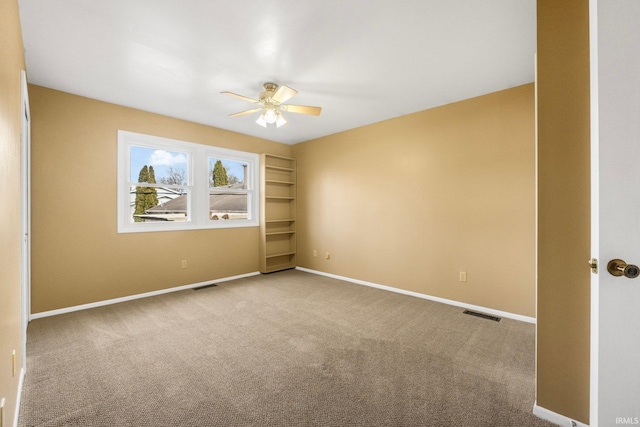 carpeted empty room with built in features and ceiling fan