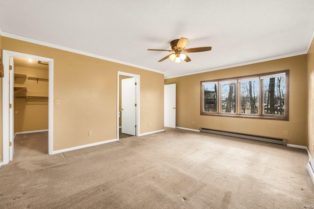 unfurnished bedroom with a baseboard heating unit, ornamental molding, a spacious closet, light colored carpet, and a closet