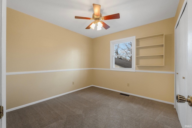 carpeted empty room featuring ceiling fan