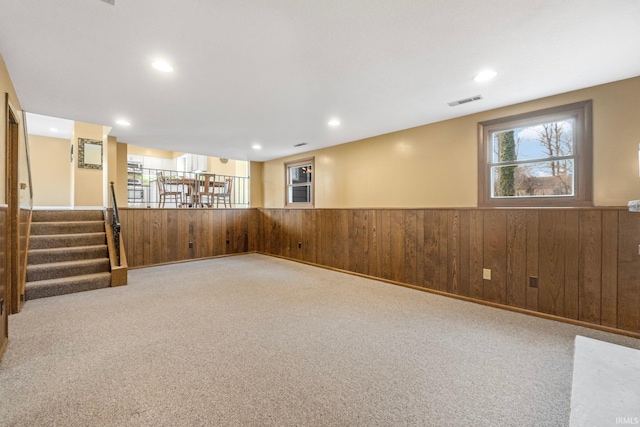 basement with light colored carpet and wooden walls