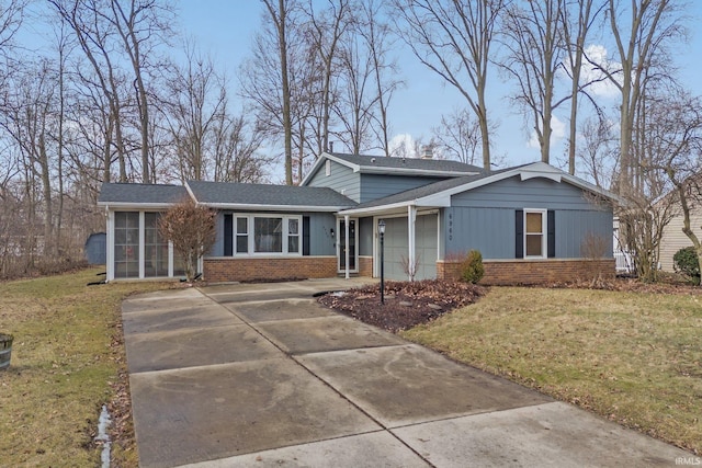 view of front of property featuring a garage, a front lawn, and a sunroom