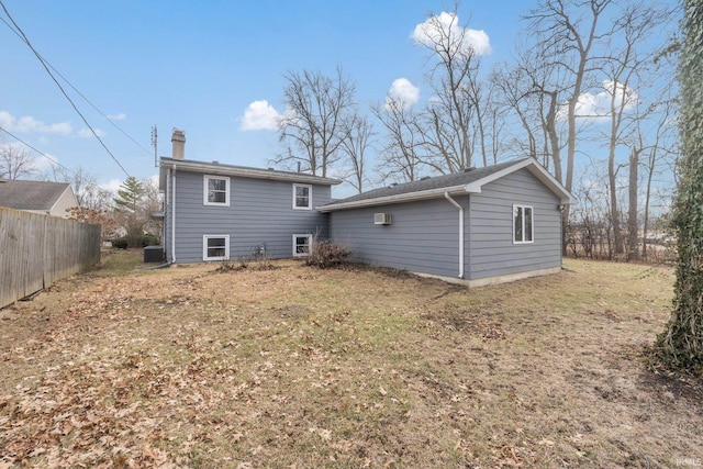 rear view of house with a lawn and central air condition unit