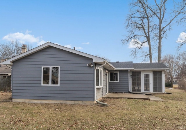 back of house with a lawn, a sunroom, and a patio area