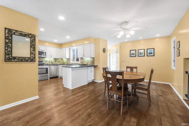 dining room featuring dark wood-type flooring, sink, and ceiling fan