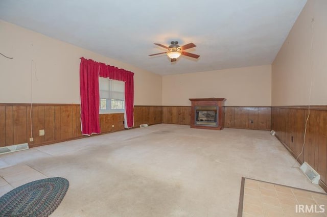 living room featuring wooden walls, light colored carpet, and ceiling fan