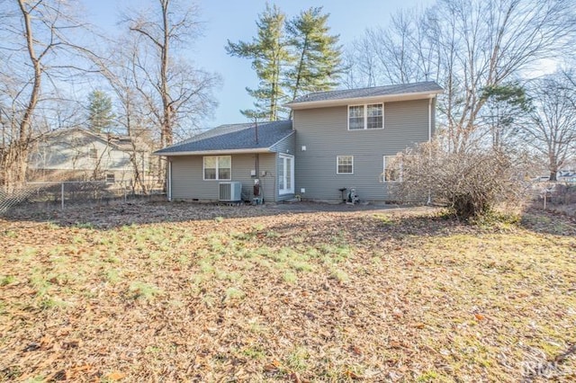 back of house with central AC unit and a lawn