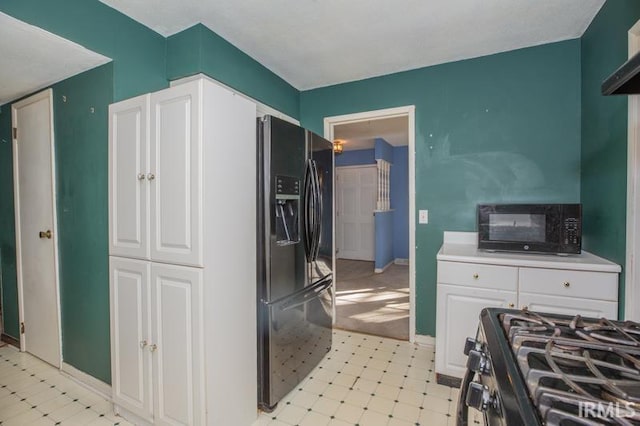 kitchen with white cabinetry and black appliances