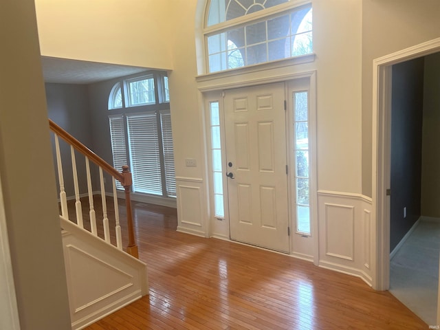 foyer with hardwood / wood-style flooring and a towering ceiling