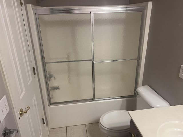 full bathroom featuring bath / shower combo with glass door, vanity, tile patterned floors, and toilet