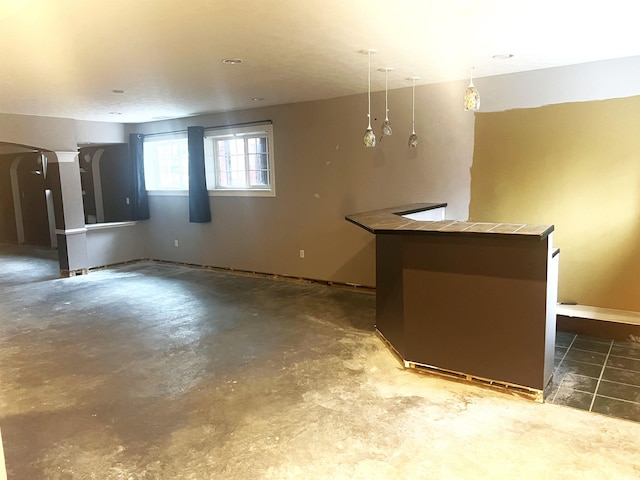 kitchen featuring pendant lighting and concrete floors