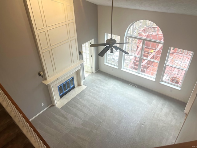 carpeted living room featuring a fireplace and ceiling fan